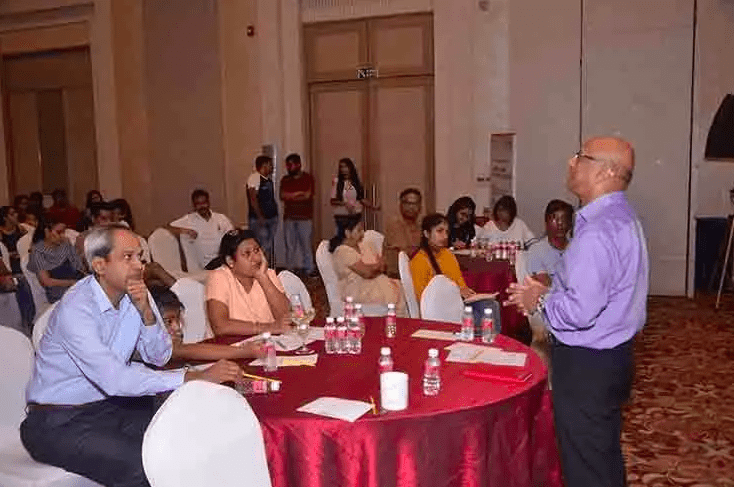 Addressing students and parents at an education seminar.